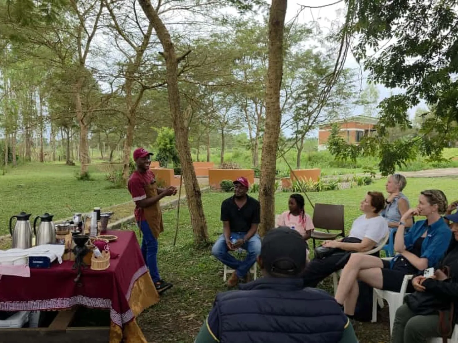A full board safari group gathered for a guided coffee brewing session under the trees